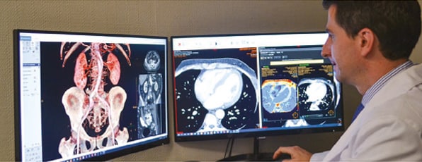 Profesional comprobando tomografías y resonancias magnéticas en el monitor